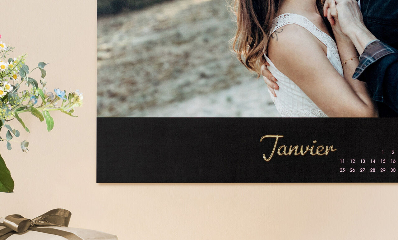 Couple s'embrassant, un calendrier du mois de janvier à leurs côtés.
