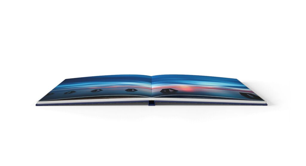 Livre photo CEWE ouvert avec des images colorées et des paysages