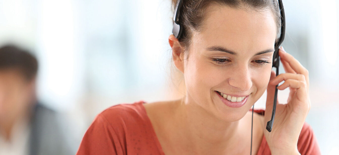 Femme avec un casque au téléphone, sympathique et engagée.