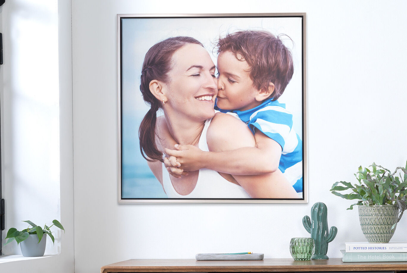 Un portrait affectueux d'une mère avec son enfant qui est assis sur ses épaules, tous deux rayonnent de bonheur.