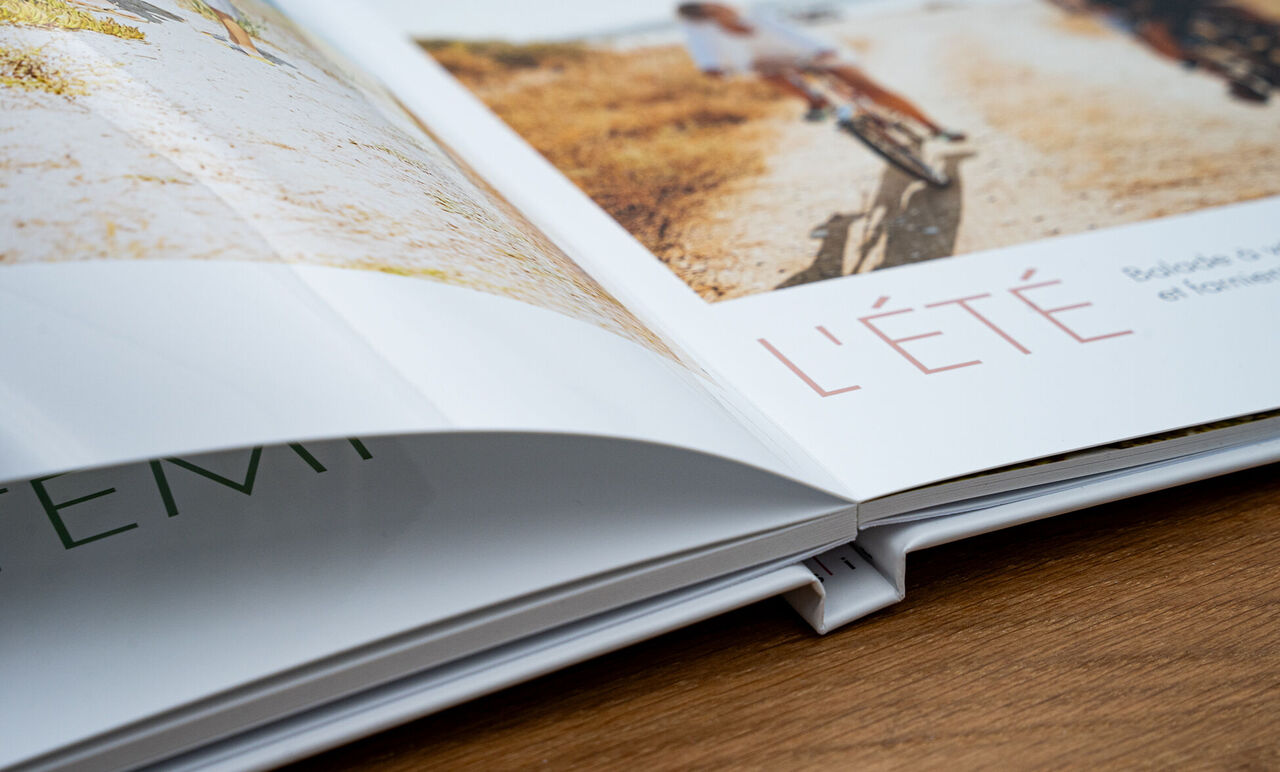 CEWE PHOTO BOOK ouvert avec des pages colorées et des motifs de vélo.