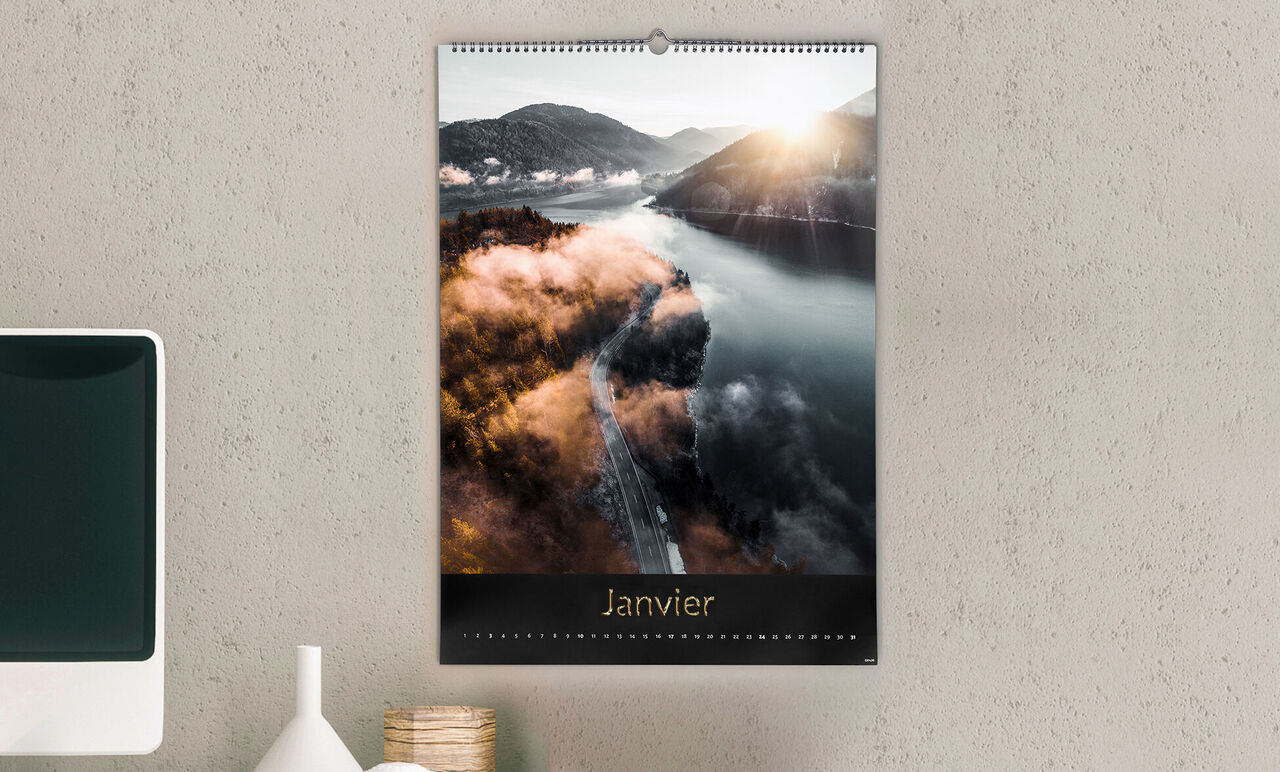 Un calendrier avec une photo de paysage d'une rivière en janvier, entourée de montagnes et de brouillard.