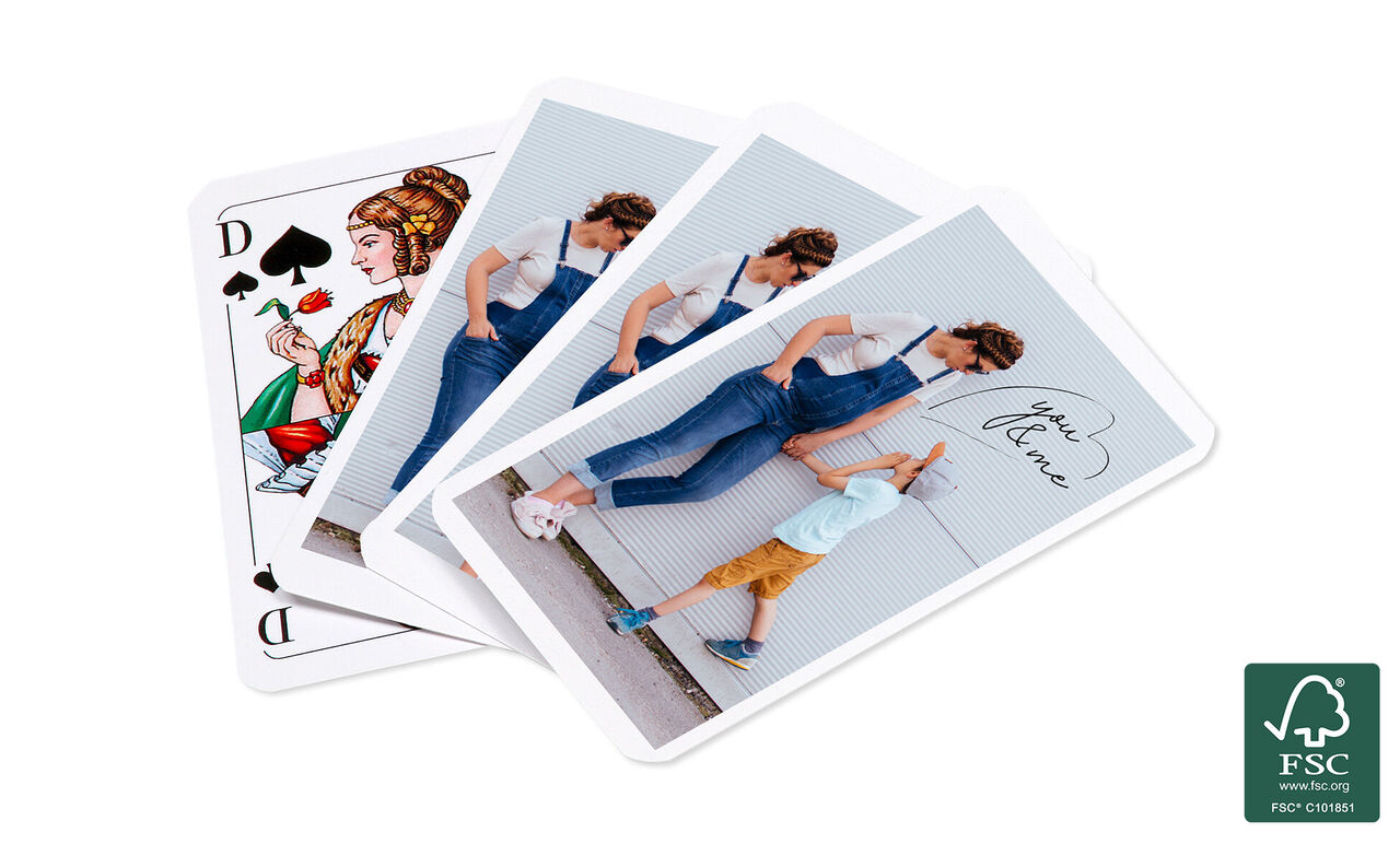 Une scène ludique montre une mère jouant aux cartes avec son petit fils. Les cartes sont colorées et présentent des illustrations créatives. L'ambiance est joyeuse et pleine de vie.