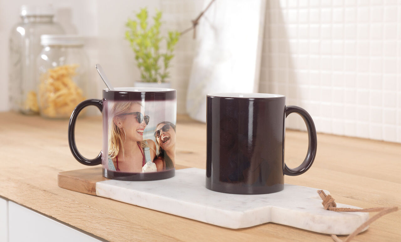 Deux tasses sur une planche en bois, l'une avec une impression photo personnelle.