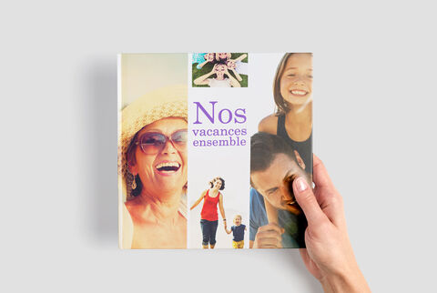 Un CEWE livre photo avec des photos de vacances, tenu dans une main.