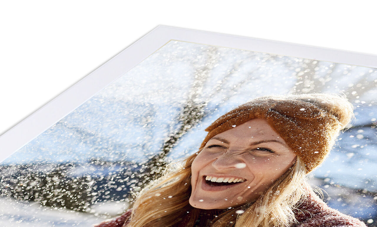 Une personne dans un parc d'hiver avec un chapeau et de la neige en arrière-plan