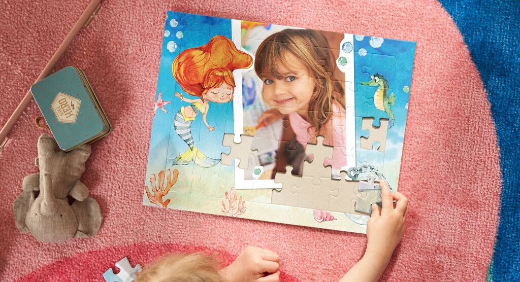 Puzzle d'une fillette personnalisé en cours d’assemblage sur un tapis rose