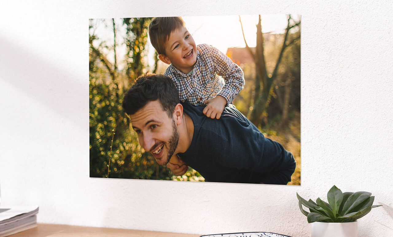 Père avec un enfant sur le dos au coucher de soleil dans le parc.