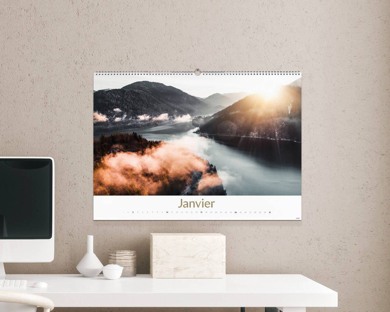 Un calendrier mural montre un paysage montagneux fantastique avec un lever de soleil en arrière-plan. Le mois de janvier est en dessous.