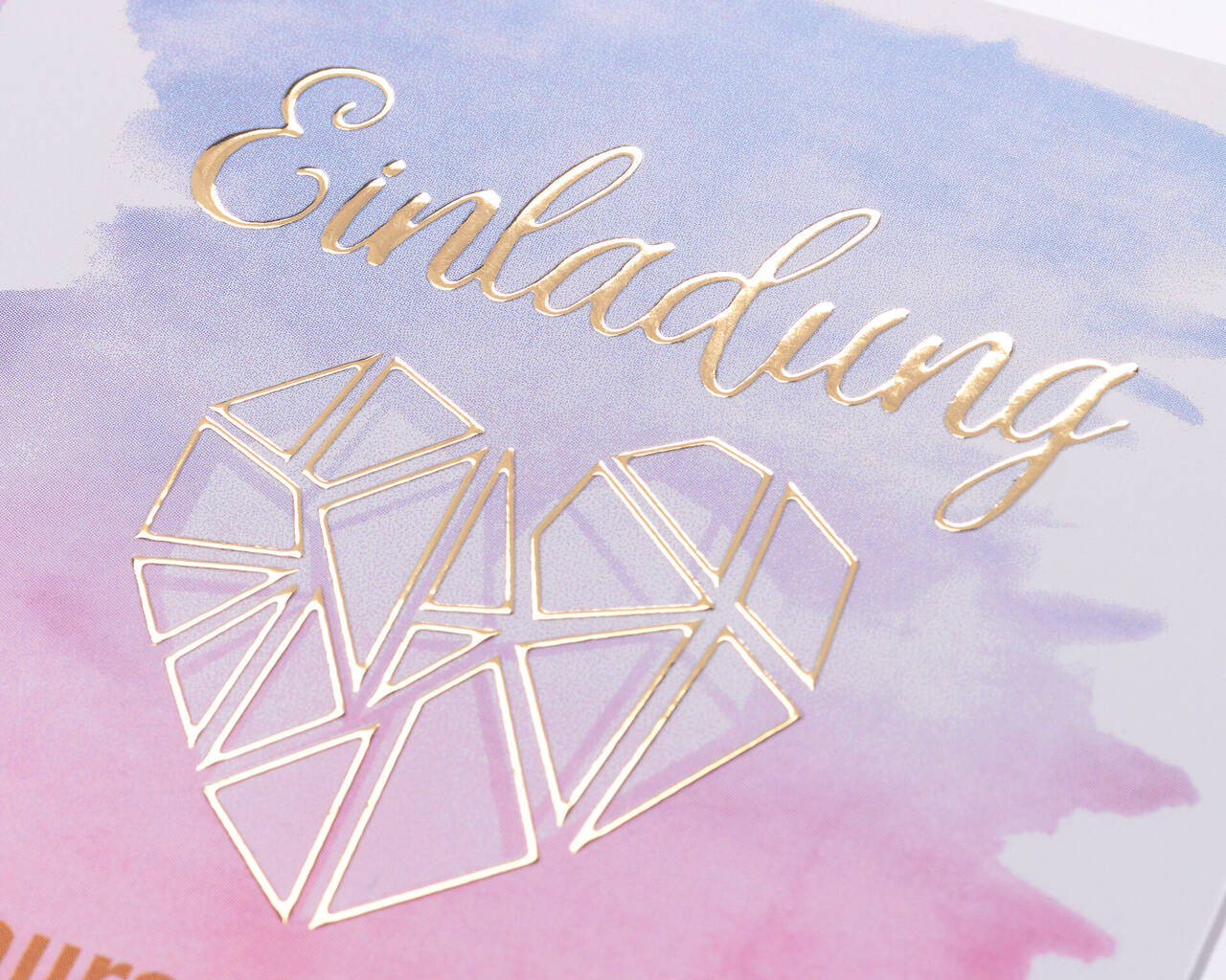 Carte d'invitation avec un design géométrique en forme de cœur doré sur fond pastel.