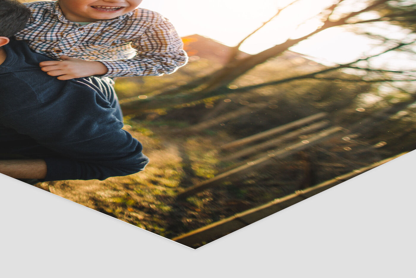 Un père porte son fils heureux sur ses épaules au coucher de soleil dans la nature.