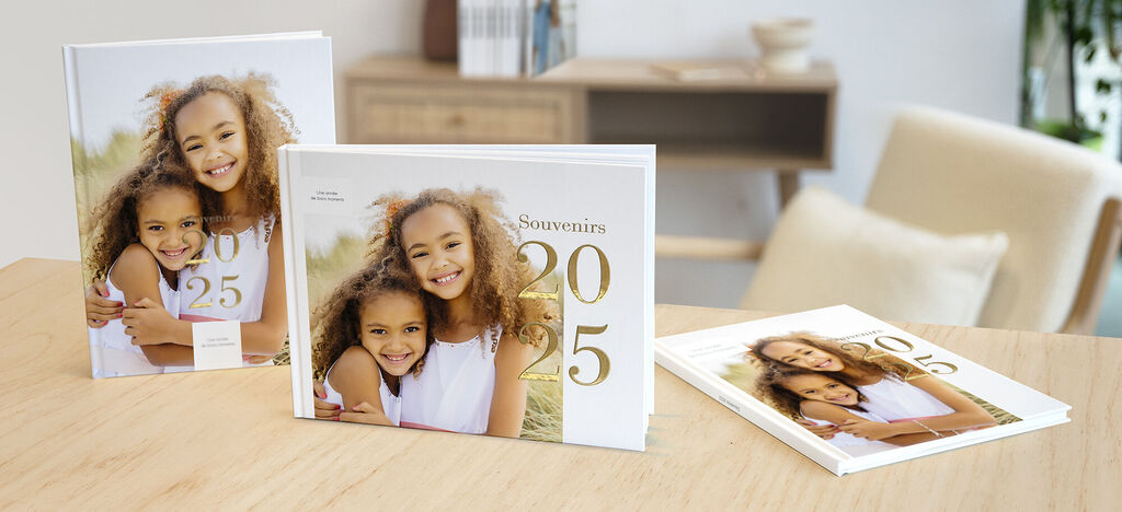 Trois CEWE Fotobooks sur une table montrant de beaux souvenirs