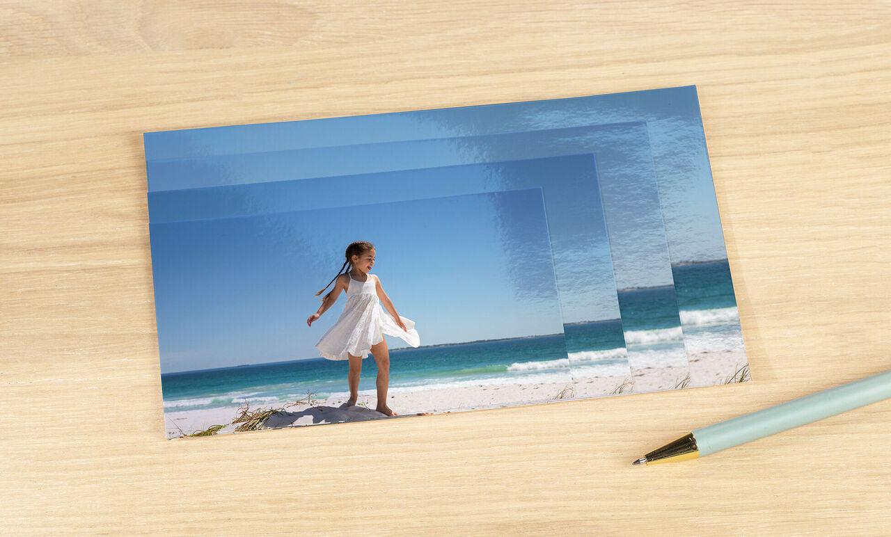 Une fille joyeuse en robe blanche se tient sur la plage et regarde l'eau.