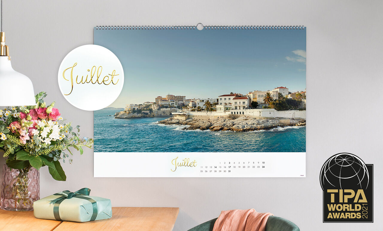 Un magnifique calendrier photo avec vue sur la côte en juillet, une mer bleue claire et une ville pittoresque.