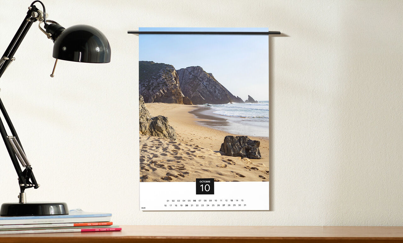 Un calendrier mural avec une œuvre d'art d'une plage avec des rochers et des vagues. Le mois de septembre est bien visible.