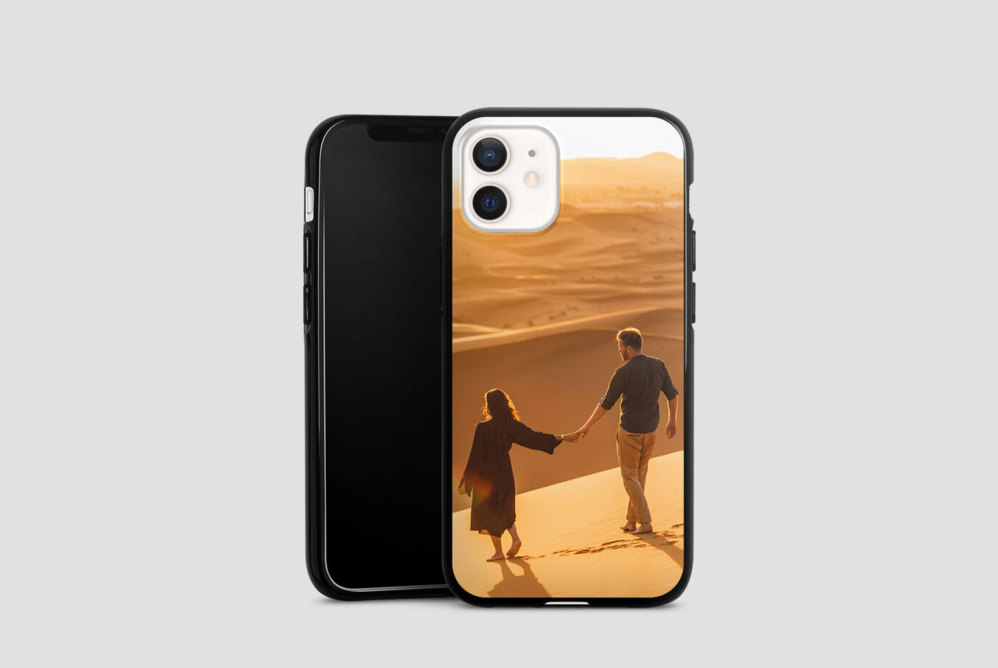 Un couple se tient la main en marchant sur une dune de sable, entouré d'une lumière douce.