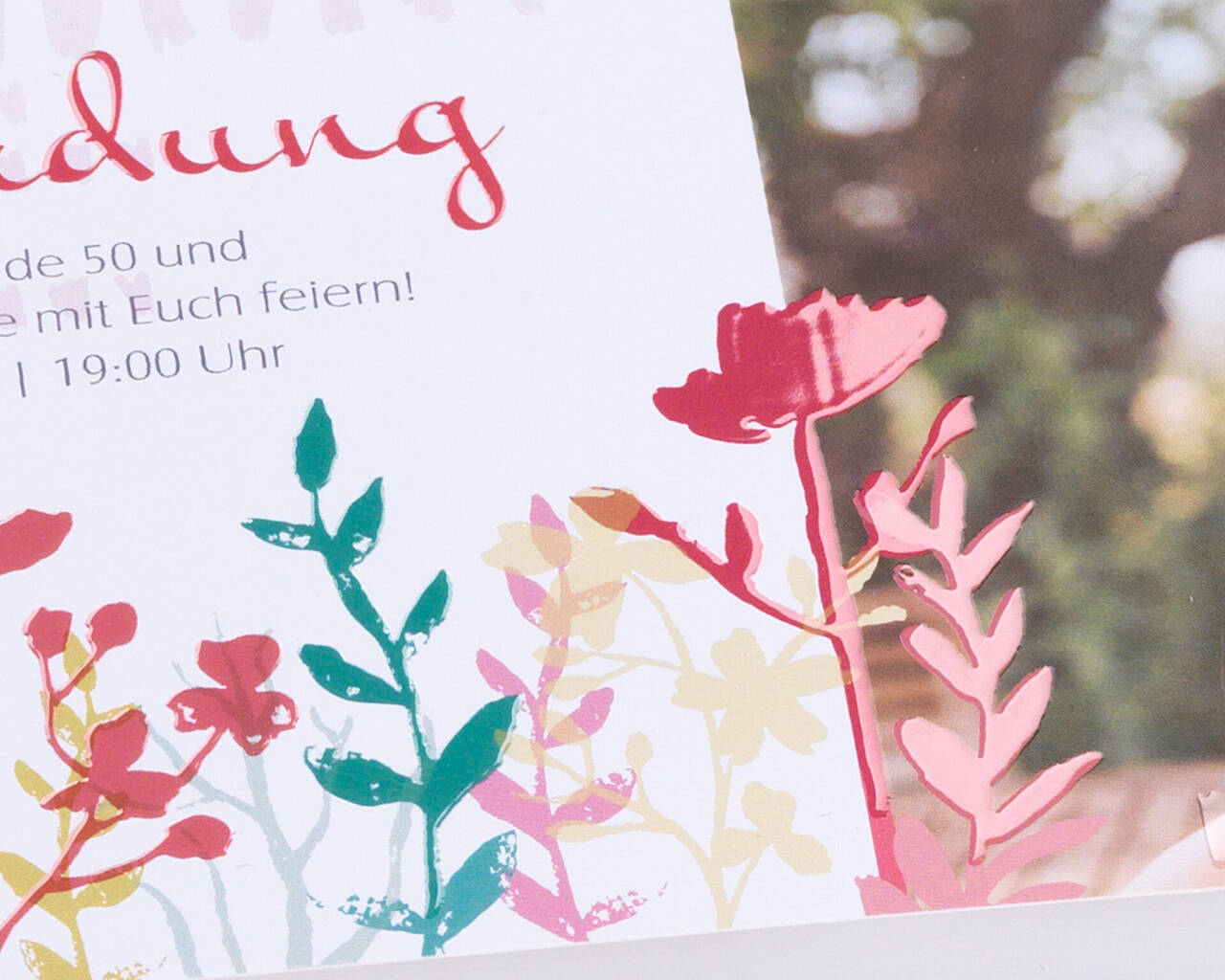 Carte d'invitation colorée avec des motifs floraux pour une fête.