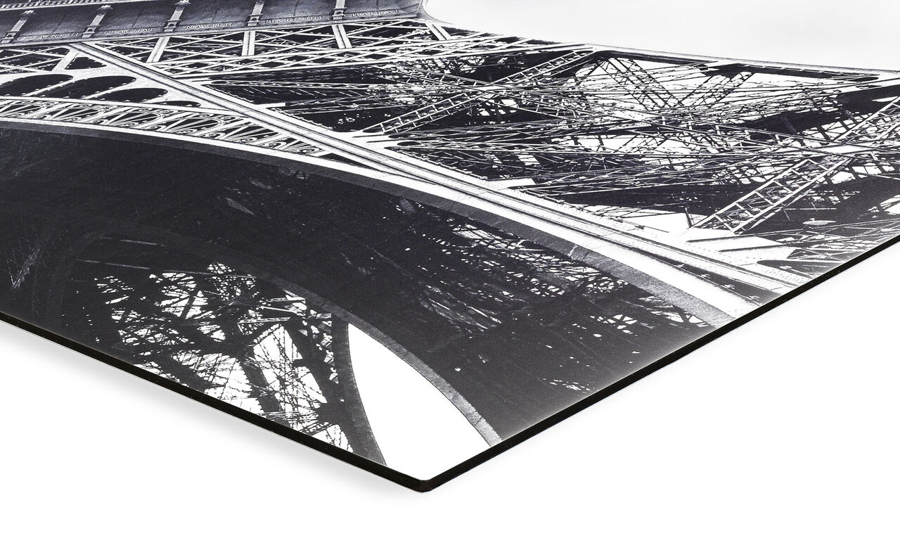 Vue détaillée de la structure artistique de la tour Eiffel en noir et blanc.