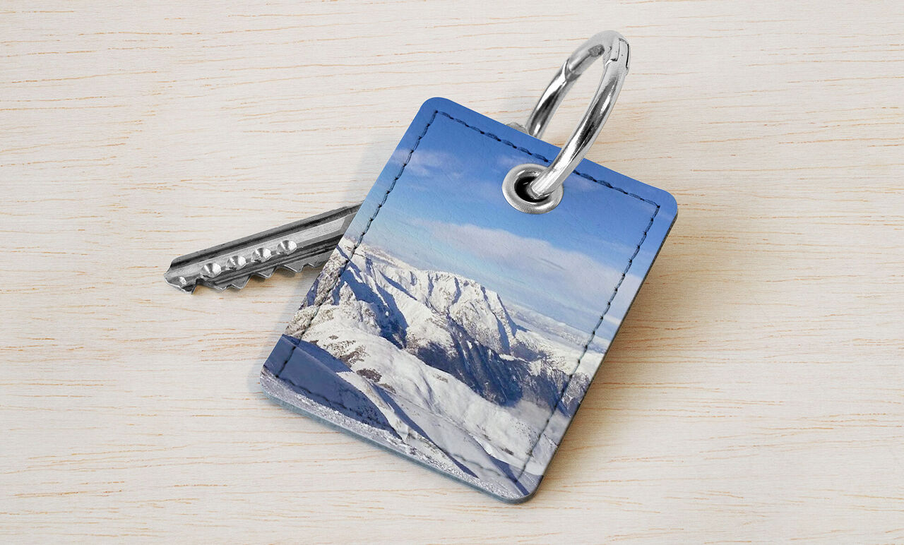 Porte-clés bleu avec un panorama de montagne dans les Alpes sous le soleil.