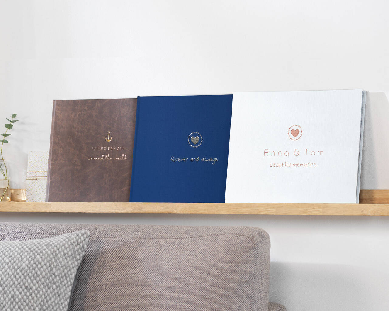 Trois livres photo élégants sur une étagère, avec une couverture douillette en dessous.