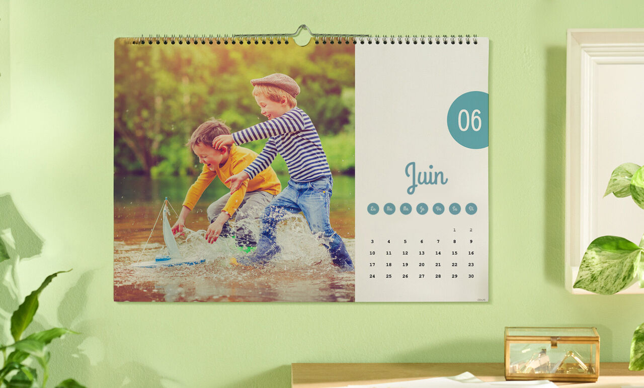 Deux enfants jouent joyeusement avec un bateau dans l'eau, entourés par la nature.