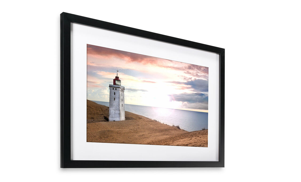 Un magnifique phare sur la côte, entouré de douces collines et d'un coucher de soleil pittoresque.