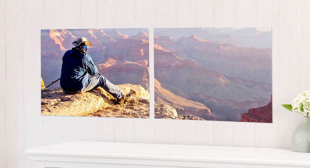 Une personne assise sur un rocher au Grand Canyon admire la vue. Les couleurs sont chaudes et le paysage est majestueux.