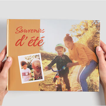 Une personne montre un album photo coloré avec des photos de vacances.