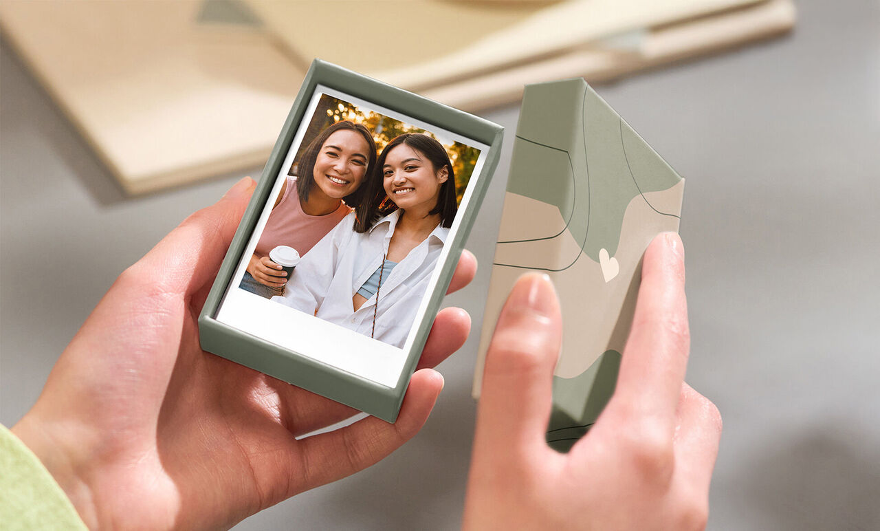 Deux femmes tiennent un emballage photo avec un Polaroid.