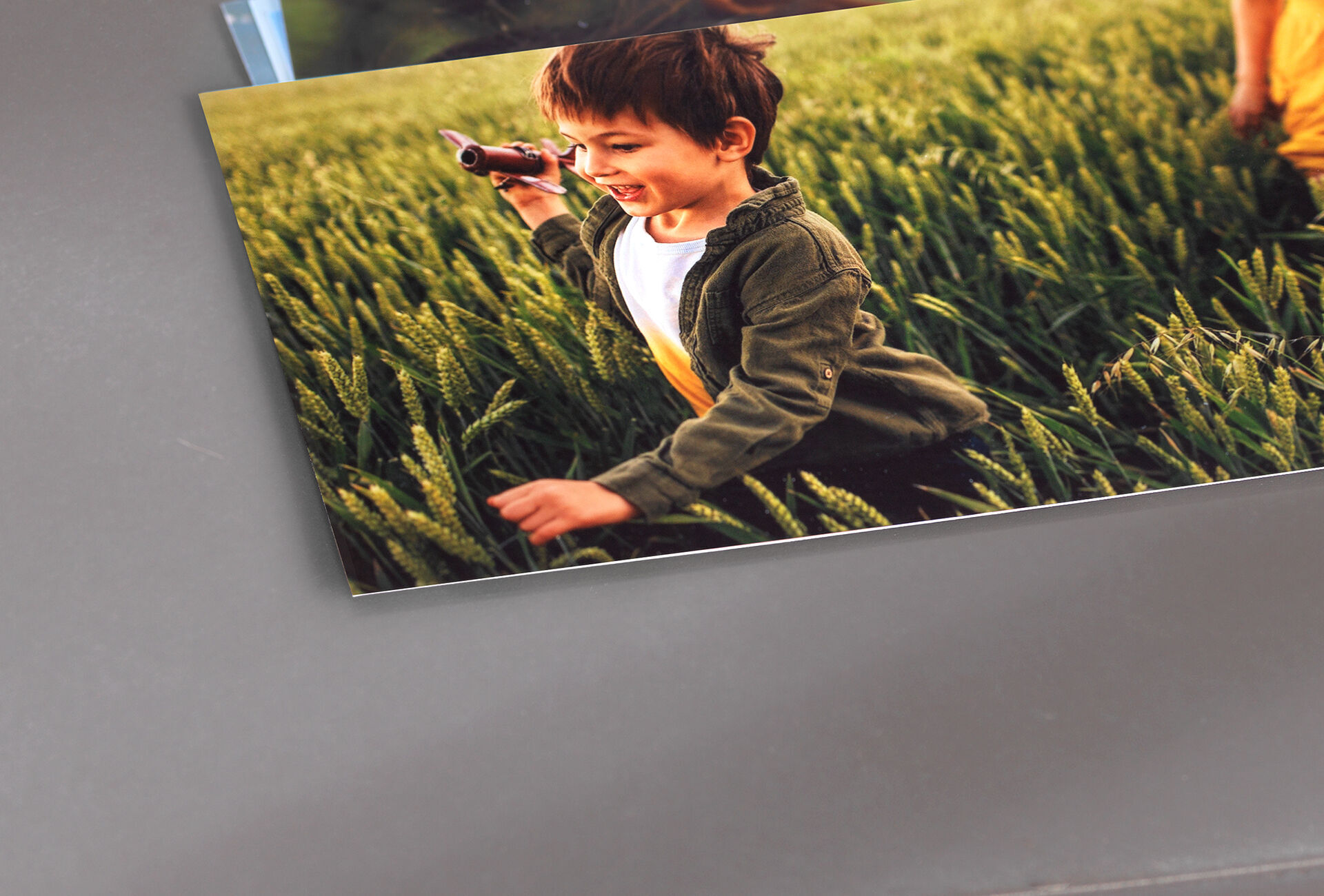 Un enfant dans un champ de blé tient un pistolet jouet et sourit. Il rayonne de joie de vivre et profite de la liberté.