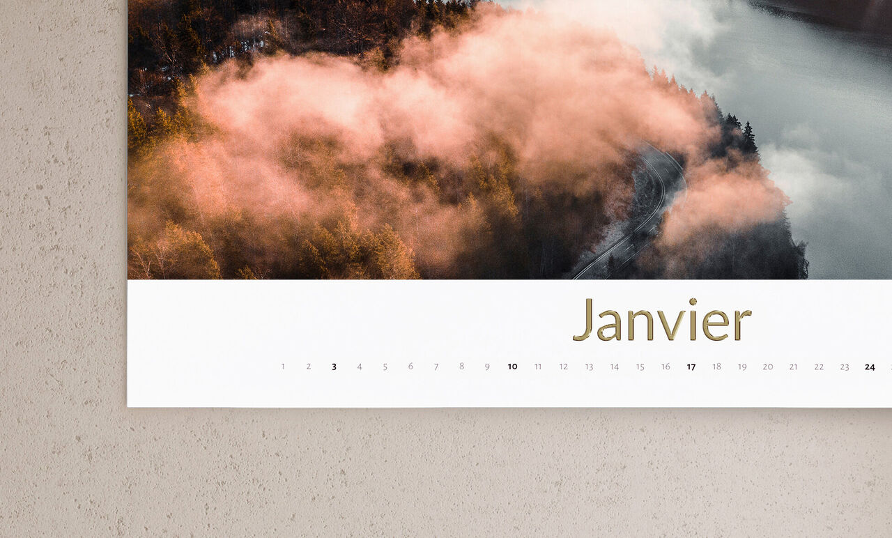 Une page de calendrier pour janvier montre un magnifique paysage avec du brouillard et des arbres aux couleurs chaudes