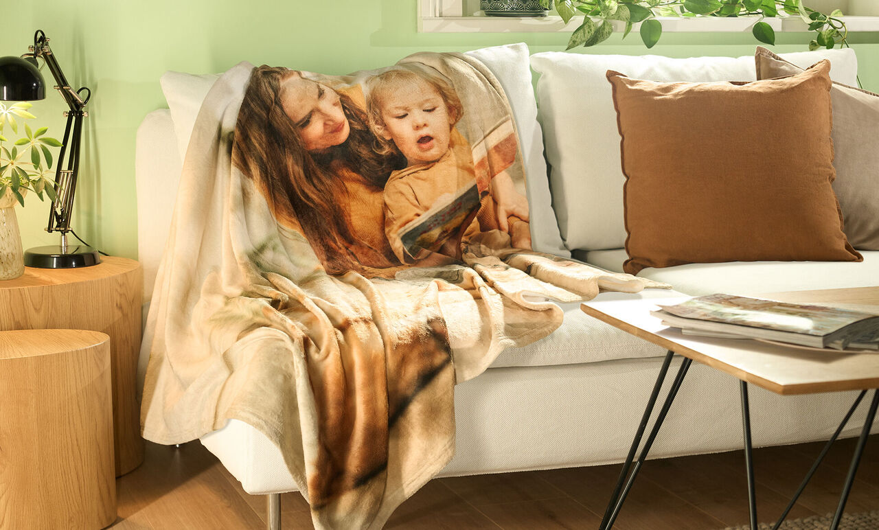 Magnifique couverture sur un canapé confortable, entourée de plantes et d'un coussin.