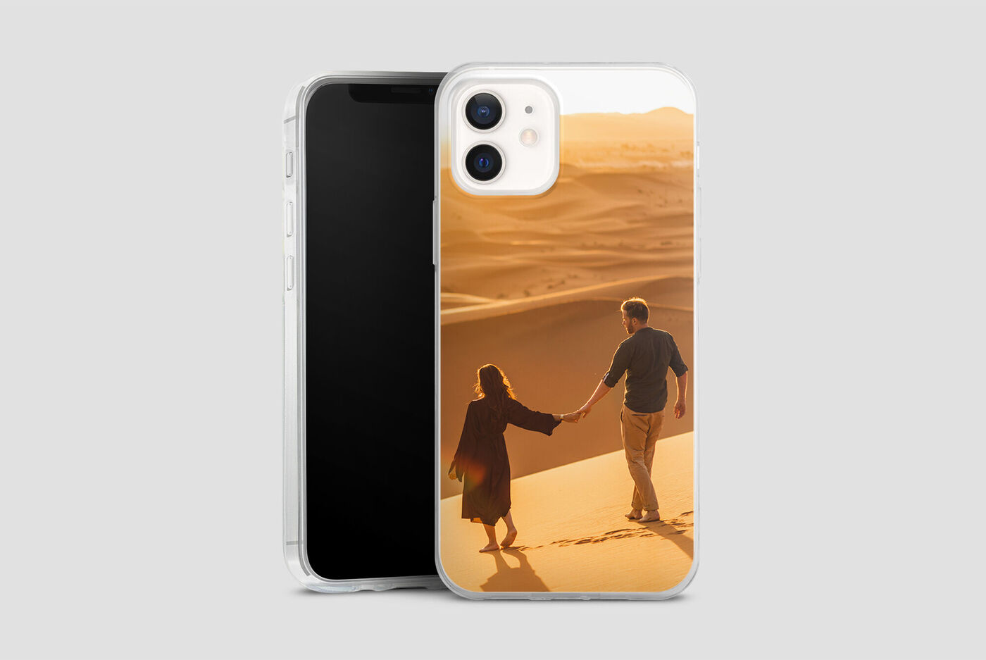 Le couple se tient la main sur la plage au coucher du soleil