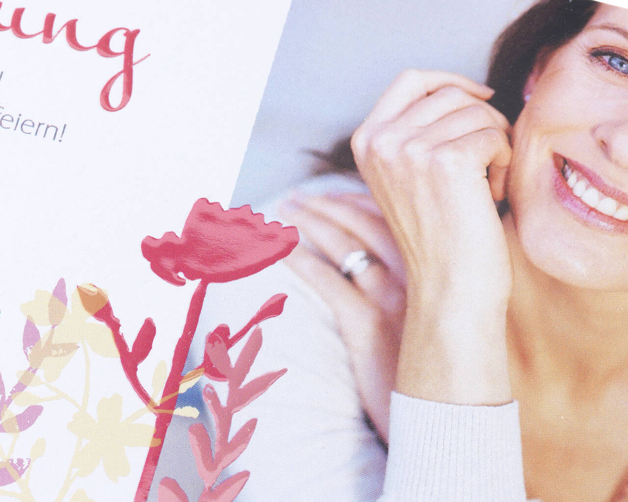 Une femme souriante tient une carte floral.
