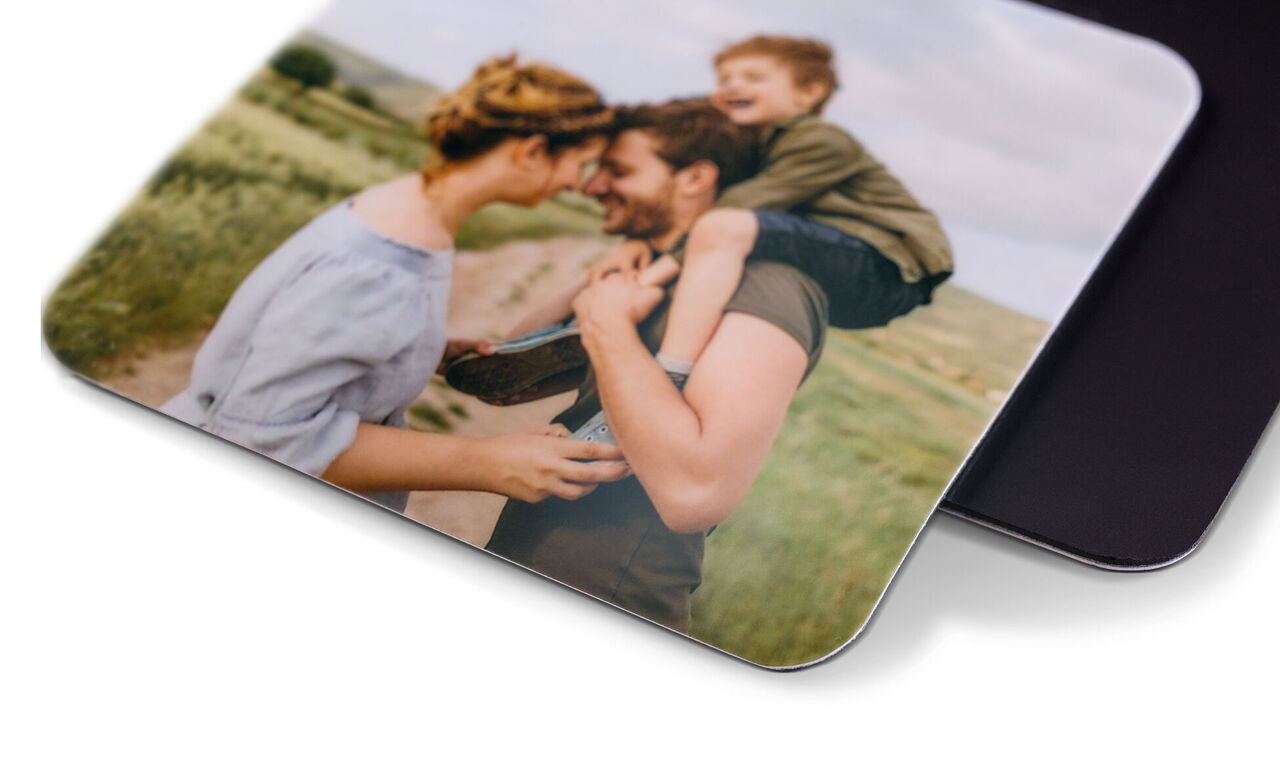 Un couple heureux avec un enfant sur le dos du père, dans un beau paysage de prairie.