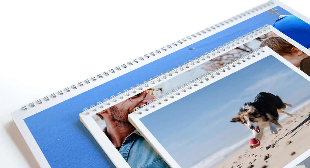 Trois calendriers photo CEWE avec différentes images sur une table.