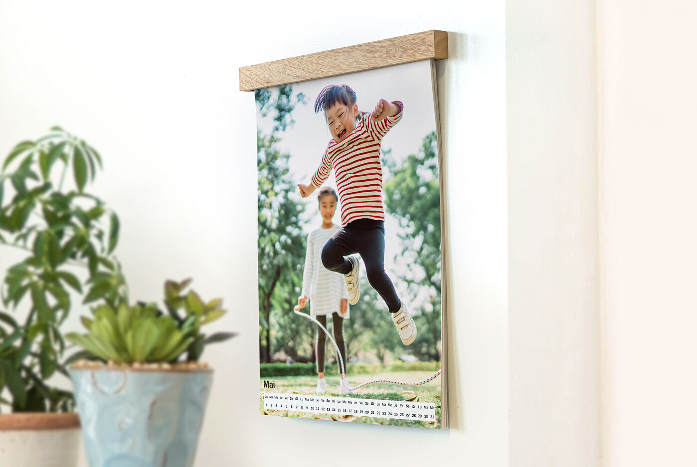 Un enfant joyeux saute d'un banc, pendant qu'un autre enfant sourit en arrière-plan, représenté sur un calendrier.
