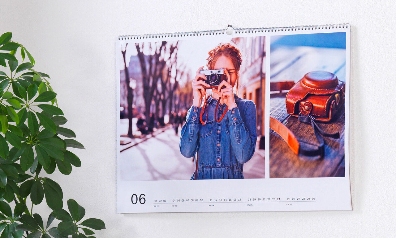 Feuille de calendrier avec une photo d'une personne et d'une caméra, ville éclairée en arrière-plan.