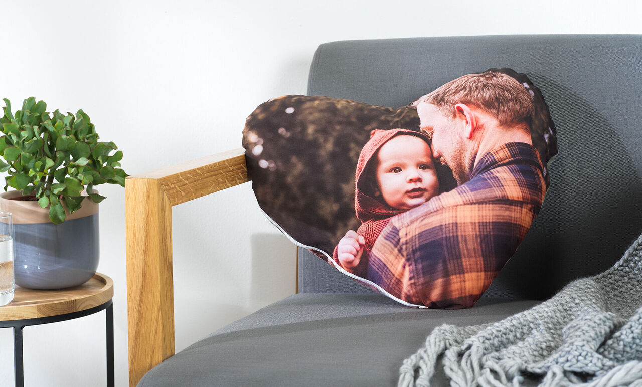 Coussin en forme de cœur avec une photo d'un homme et d'un enfant en plein air.