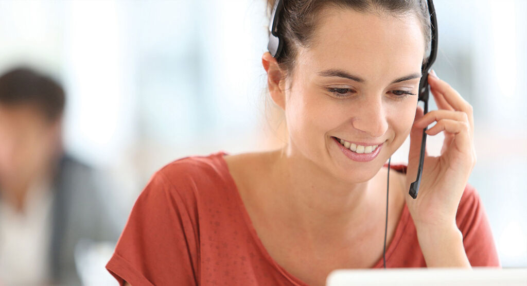 Une conseillère amicale avec un casque offre son aide au téléphone.