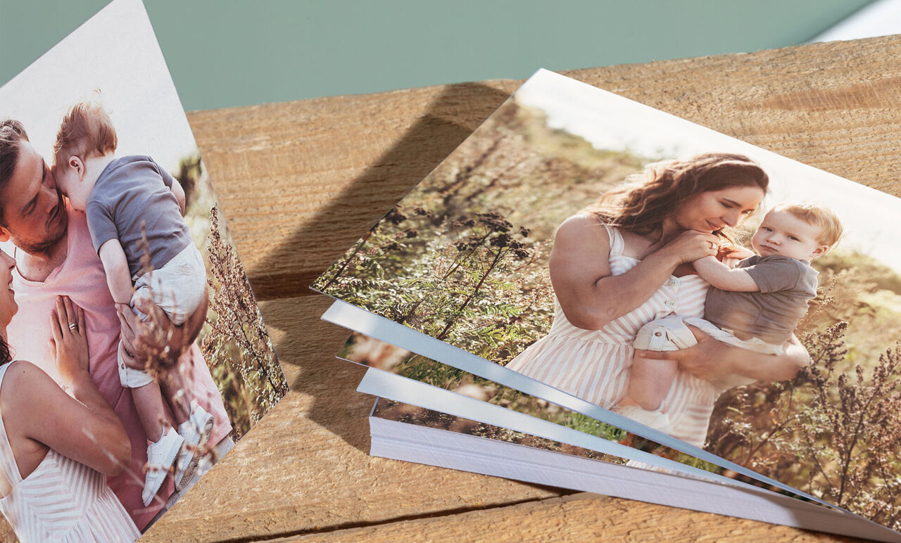 Deux albums photo sur une table, une mère et son enfant regardent l'un d'eux, l'autre montre une famille heureuse dans la nature.