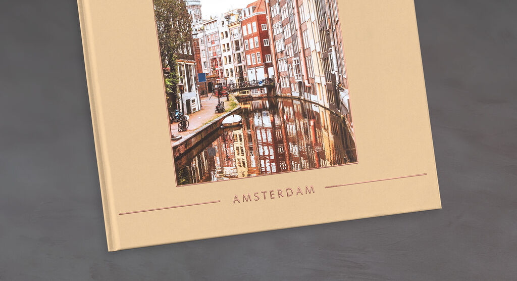 Un CEWE Fotobuch avec une image des rues et canaux gris d'Amsterdam.