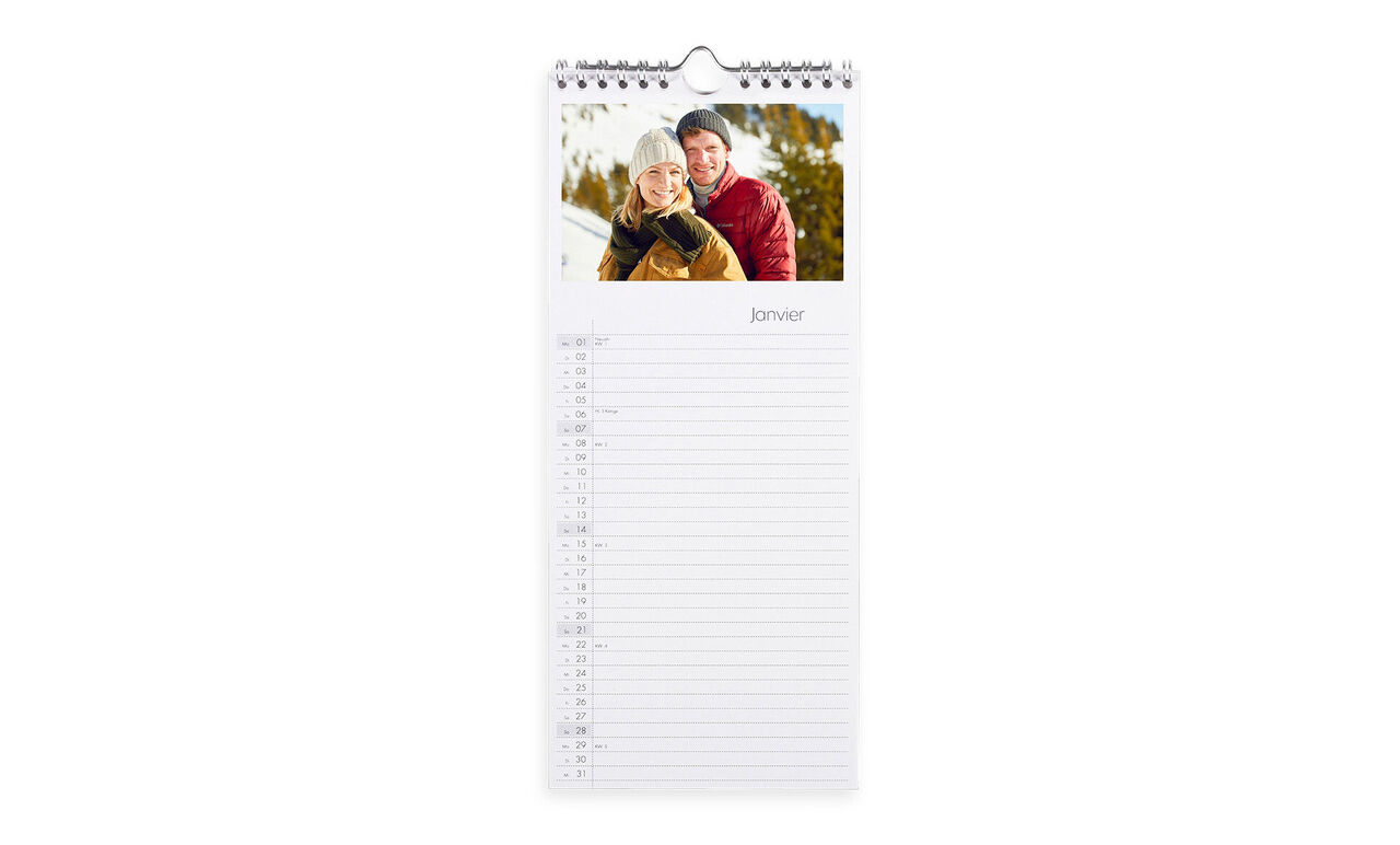 Calendrier photo CEWE recto-verso avec motif d'hiver d'un couple souriant à l'extérieur.