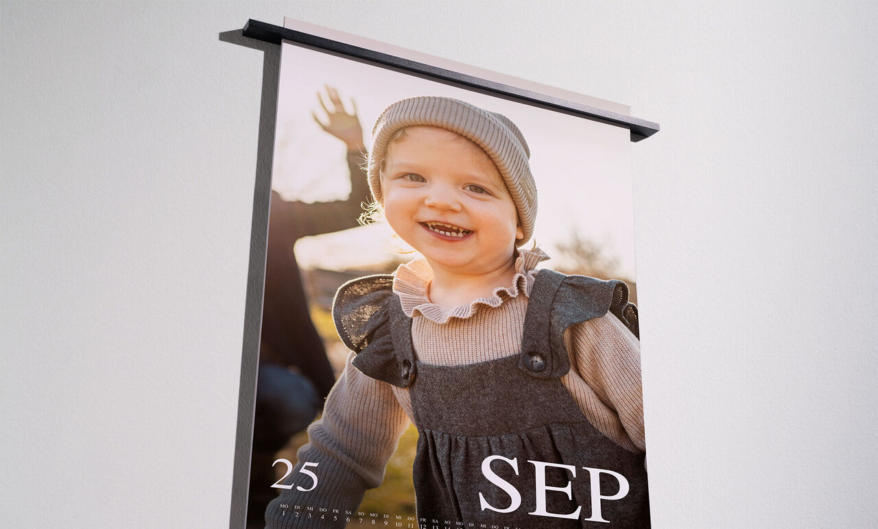 Un calendrier photo soigneusement conçu avec une image d'un enfant heureux à l'extérieur, souriant à la caméra et montrant les mains