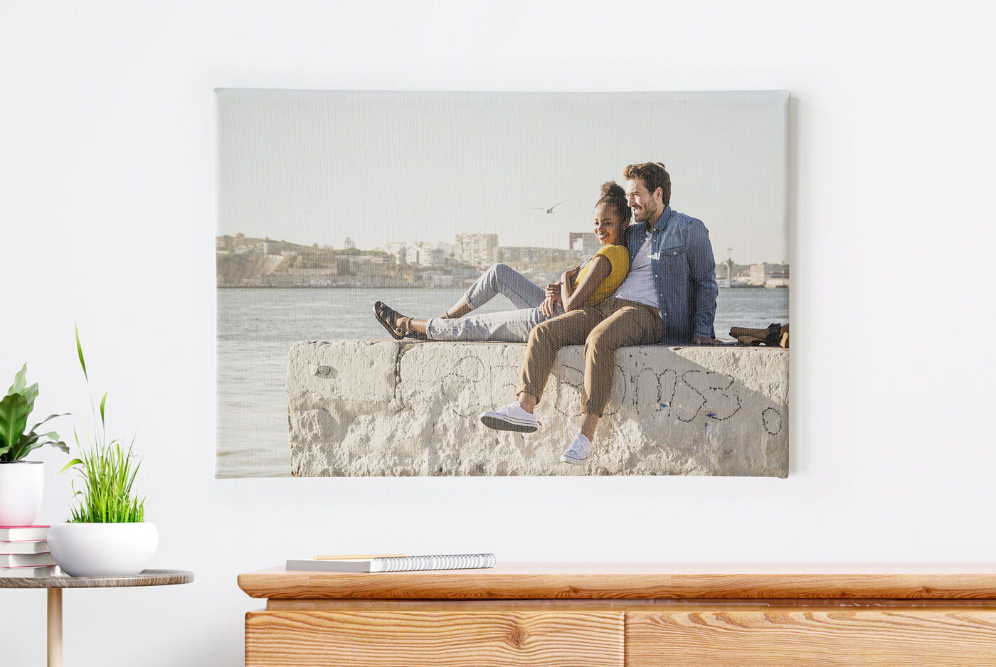 Un couple est assis au bord de la mer sur un mur de pierre, appréciant la vue
