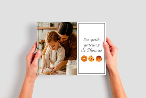 Une scène affectueuse où une mère apprend à cuisiner avec sa fille. Elles tiennent un livre de recettes.